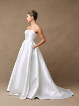 Side view of off-white wedding ball gown with pockets and sweeping train